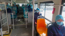 Para petugas medis dari Rumah Sakit Afiliasi Universitas Qingdao duduk berjauhan dalam bus untuk mencegah risiko infeksi silang virus corona saat mereka kembali ke hotel setelah bekerja di Wuhan, China pada 20 Februari 2020. (Xinhua/Cai Yang)