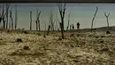 Orang-orang berjalan di dekat perbatasan waduk Yesa yang terkena dampak kekeringan, pada hari musim panas yang cerah di Yesa, sekitar 55 kilometer (34,17 mil), dari Pamplona, Spanyol utara, Rabu, 14 September 2022. (AP Photo/Alvaro Barrientos )