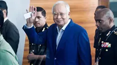 Mantan Perdana Menteri Najib Razak melambaikan tangan setibanya di kantor Komisi Anti-Korupsi Malaysia (MACC), Putrajaya, Selasa (22/5). Najib hari ini menjalani pemeriksaan terkait kasus korupsi 1Malaysia Development Berhad (1MDB). (AP/Sadiq Asyraf)