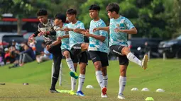 Pemain Timnas Indonesia U-16, Tristan Raisa Ibrahim (kanan) dkk melakukan pemanasan sebelum laga uji coba menghadapi SSB Terang Bangsa di Lapangan Yogyakarta International School (YIS), Jumat (31/5/2024). (Bola.com/Radifa Arsa)