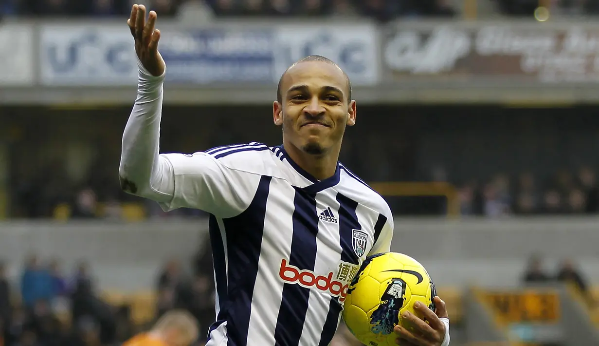 Selebrasi striker West Bromwich Albion, Peter Odemwingie setelah mencetak gol ke gawang Wolverhampton pada laga Liga Inggris 2011/2012 di Molineux Stadium, Wolverhampton (12/2/2012). Peter Odemwingie total membela 3 klub EPL di Liga Inggris selama 5,5 musim, yaitu West Bromwich Albion, Cardiff City dan Stoke City. Torehan 15 gol menjadi catatan terbaiknya pada musim 2010/2011 bersama West Bromwich Albion. (AFP/Ian Kington)
