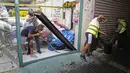 Sejumlah pria membersihkan pecahan kaca dari sebuah toko usai serangan roket yang ditembakkan dari Jalur Gaza jatuh di Kota Ashdod, Selasa (15/9/2020). Serangan yang terjadi saat Israel menandatangani kesepakatan normalisasi dengan Bahrain dan UEA ini mengakibatkan dua orang terluka. (JACK GUEZ/AFP)