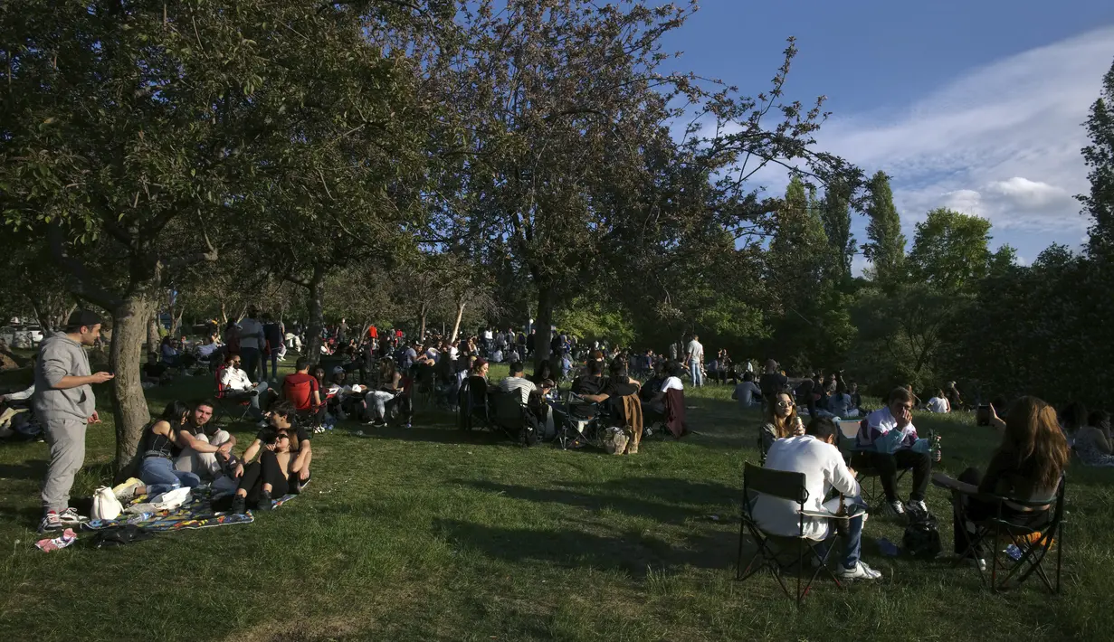 Orang-orang menikmati cuaca yang cerah di taman, beberapa jam setelah penguncian penuh selama 17 hari berakhir, di Ankara, Senin (17/5/2021). Saat ini infeksi di Turki telah turun menjadi kurang dari 15 ribu per hari dari sekitar 40 ribu pada awal lockdown pada akhir April (AP Photo/Burhan Ozbilici)