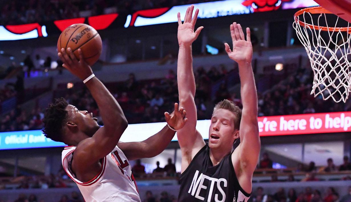 Aksi pemain Chicago Bulls, Jimmy Butler (kiri) melakukan tembakan saat dihadang pemain  Brooklyn Nets, Justin Hamilton #41 pada lanjutan NBA basketball game, (28/12/2016) di United Center.  Bulls menang 101-99. (Reuters/Mike DiNovo-USA TODAY Sports)