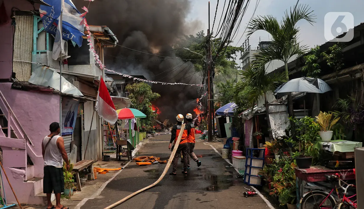 Petugas pemadam kebakaran berusaha memadamkan api saat terjadi kebakaran di kawasan padat penduduk di Jalan Simprug Golf II RT 4/8, Grogol Selatan, Kebayoran Lama, Jakarta Selatan, Minggu (21/8/2022). Belum diketahui penyebab kebakaran yang membakar puluhan rumah tersebut. (Liputan6.com/Angga Yuniar)