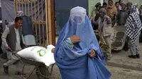 Seorang perempuan Afghanistan menunggu untuk menerima jatah makanan yang didistribusikan oleh kelompok bantuan kemanusiaan Korea Selatan, di Kabul, Selasa (10/5/2022). Taliban pada Sabtu pekan lalu memerintahkan semua perempuan Afghanistan menutupi seluruh tubuhnya atau mengenakan burqa tradisional di depan umum. (AP Photo/Ebrahim Noroozi)