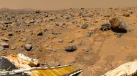 Bagian panorama  dari kamera IMP yang dipasang di tiang lander "Mars Pathfinder" NASA, mencakup "Puncak Kembar" di cakrawala, dan penjelajah Sojourner di sebelah batu yang disebut "Yogi". Gambar diambil pada 1997. (NASA / JPL)