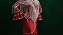 Seorang wanita mengenakan pakaian tradisional berpose untuk difoto saat mengikuti "Romeria de El Rocio" di Fitero, Spanyol utara (26/5). Mereka mengikuti "Romeria de El Rocio" untuk menghormati Perawan Rocio. (AP/Alvaro Barrientos)
