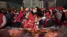 Seorang peserta membuat kimchi, hidangan tradisional Korea Selatan, selama Festival Kimchi tahunan di pusat kota Seoul, Jumat (3/11). Kimchi merupakan makanan yang terbuat dari sawi putih atau lobak yang difermentasikan. (Ed JONES/AFP)