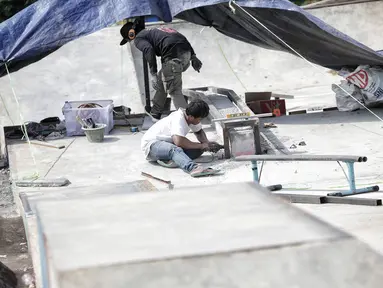 Pekerja memperbaiki arena skateboard yang rusak di RPTRA Kalijodo, Jakarta, Kamis (24/1). Perbaikan dilakukan untuk membuat rasa aman dan nyaman pengunjung yang menggunakan arena tersebut. (Liputan6.com/Faizal Fanani)