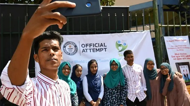 Beberapa pasangan kembar sedang berfoto sembari menunggu antrian.