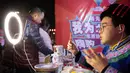 Petani yang mengenakan kostum etnis Qiang menjual produk lokal melalui siaran langsung daring (livestream) di Beichuan, Provinsi Sichuan, China, 14 November 2020. Acara livestream yang menghadirkan berbagai produk pengentasan kemiskinan dibuka di Beichuan, Sabtu (14/11). (Xinhua/Jiang Hongjing)