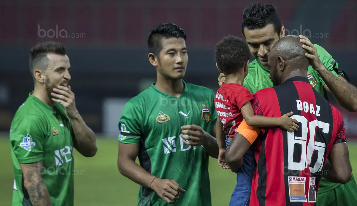 Kapten Persipura, Boaz Solossa, bersama sang putri menyapa bek Bhayangkara FC, Otavio Dutra, pada laga Liga 1 Indonesia di Stadion Patriot, Bekasi, Sabtu (9/9/2017). Bhayangkara FC menang 2-1 atas Persipura. (Bola.com/Vitalis Yogi Trisna)