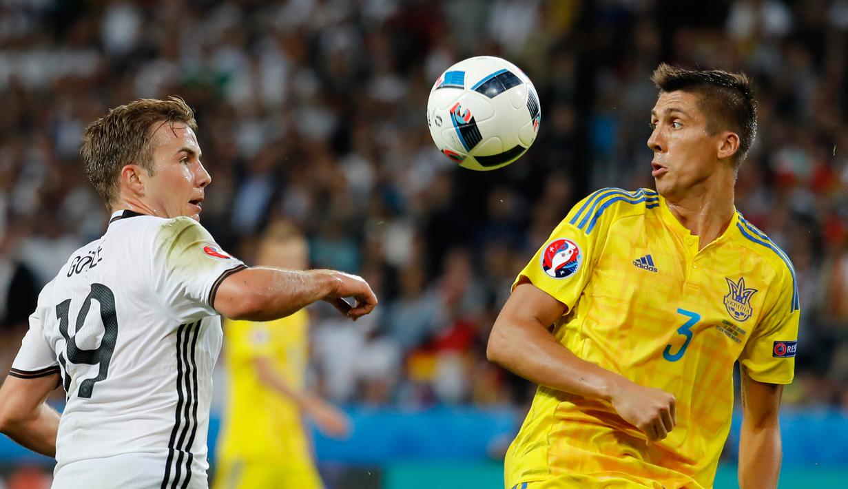Bek Ukraina, Yevhen Khacheridi (kanan) berebut bola dengan gelandang Jerman, Mario Goetze di kualifkasi grup C Piala Eropa 2016 di Stadion Stade Pierre-Mauroy, Perancis, (12/6). Jerman menang atas Ukraina dengan skor 2-0. (REUTERS/Pascal Rossignol)