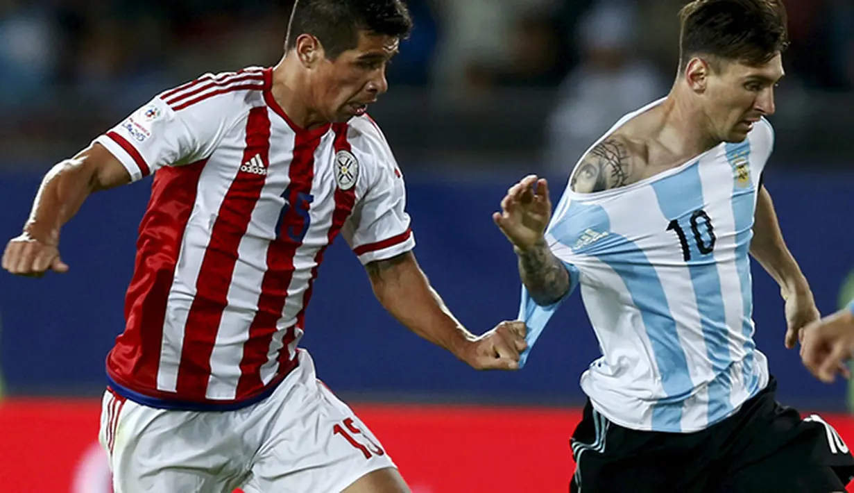 Victor Caceres (kiri) dari Paraguay menghentikan laju Lionel Messi dengan menarik bajunya di Copa America 2015, Cile. (REUTERS/Marcos Brindicci) 