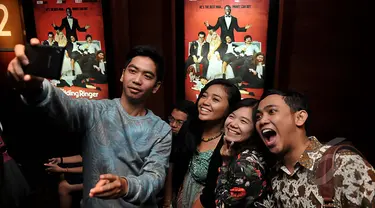 Sambil menunggu studio dibuka, penonton ini asyik selfie di depan poster film  saat Premier Film The Wedding Ringer, Jakarta, Selasa,(17/2/2015) (Liputan6.com/Johan Tallo)