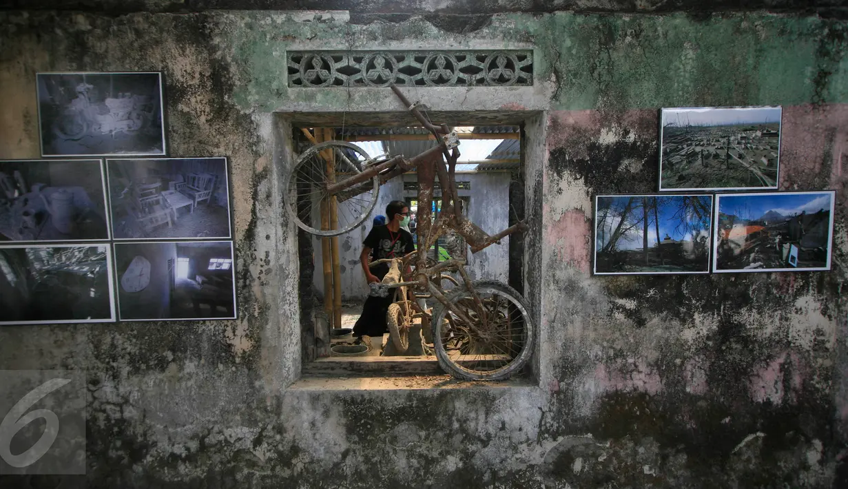 Pengunjung menyaksikan pameran foto peringatan 5 tahun letusan Merapi 2010 di Dusun Petung,Sleman,  Yogyakarta, Kamis (29/10/2015). Pameran bertempat di bekas pemukiman warga yang menjadi saksi bisu saat terjangan lahar panas erupsi Merapi. (Boy Harjanto)