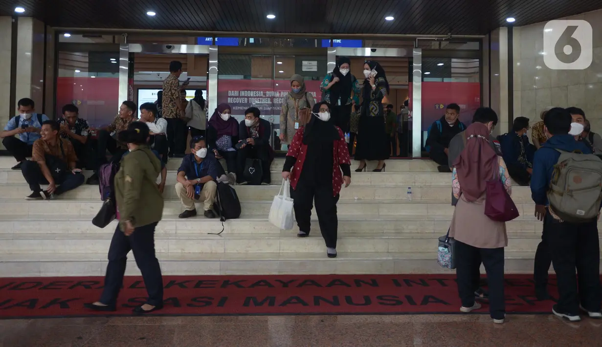 Pegawai berhamburan di luar Gedung Kemenkumham saat terjadi kebakaran, Jakarta, Kamis (8/12/2022). Kebakaran diduga disebabkan korsleting pada panel di area lantai lima. (merdeka.com/Imam Buhori)