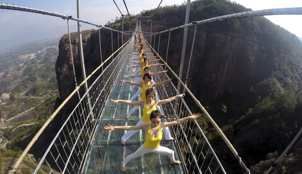 Sejumlah wanita melakukan yoga di jembatan kaca di Taman Nasional Shiniuzhai di Pingjiang, provinsi Hunan, China, Kamis (5/11). Latihan ekstrem di atas ketinggian 180 meter ini untuk mempromosikan hidup sehat dengan beryoga. (REUTERS/China Daily)