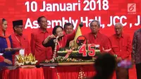 Presiden Joko Widodo dan Wapres Jusuf Kalla menyaksikan pemotongan tumpeng oleh Ketua Umum PDIP, Megawati Soekarnoputri saat perayaan HUT PDIP ke 45 di Jakarta, Rabu (10/1). (Liputan6.com/Angga Yuniar)