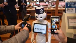 Fotografer mengambil gambar robot humanoid Pepper saat press preview di Saitama, Jepang (2/2). Pepper yang diproduksi oleh Softbank dirancang khusus dengan perangkat lunak dari perusahaan Belgia Zora Botts. (AFP/Kazuhiro Nogi)
