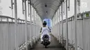 Pengendara sepeda motor melintasi JPO di Jalan Yos Sudarso, Jakarta, Senin (12/11). Aksi nekat yang dilakukan para pengendara sepeda motor demi mempersingkat rute jalan tersebut dapat membahayakan diri mereka sendiri. (Merdeka.com/Iqbal S. Nugroho)