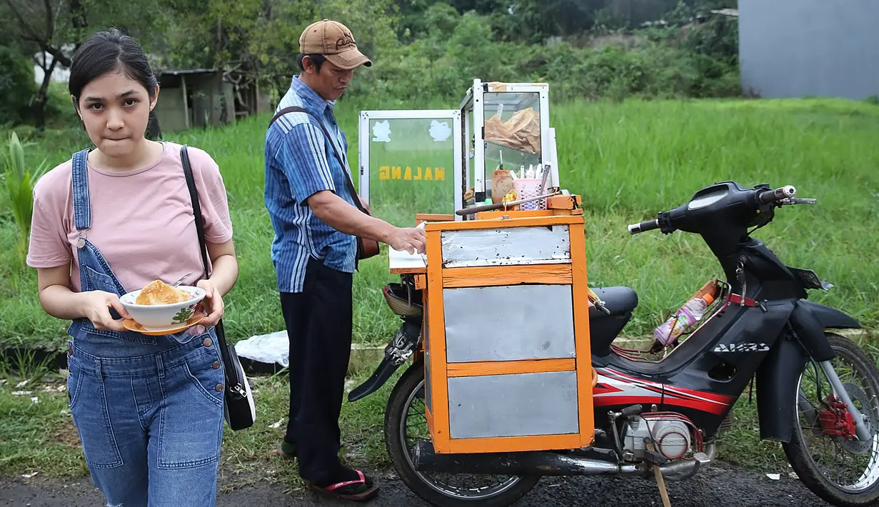 Saat waktu break tiba, terlihat Cut Syifa jajan bakso Malang. Lokasi syuting yang belum lama diguyur hujan deras, membuat cuaca di seputar lokasi syuting sedikit dingin. Makanan berkuah, cocok dengan cuaca dingin. (Bambang E. Ros/Bintang.com)