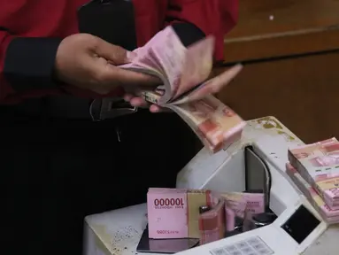 Petugas menghitung uang rupiah di penukaran uang di Jakarta, Senin (9/11/2020). Nilai tukar rupiah terhadap dolar AS bergerak menguat pada perdagangan di awal pekan ini Salah satu sentimen pendorong penguatan rupiah kali ini adalah kemenangan Joe Biden atas Donald Trump. (Liputan6.com/Angga Yuniar)