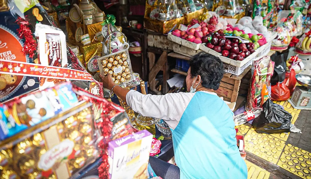 Pedagang mengemas parsel Natal di Pasar Barito, Jakarta, Kamis (23/12/2021). Pedagang mengakui penjualan parsel sebagai hantaran Natal mulai ramai. Parsel yang paling banyak diminati adalah parsel makanan dengan harga mulai dari Rp 100.000 hingga Rp 800.000. (Liputan6.com/Faizal Fanani)