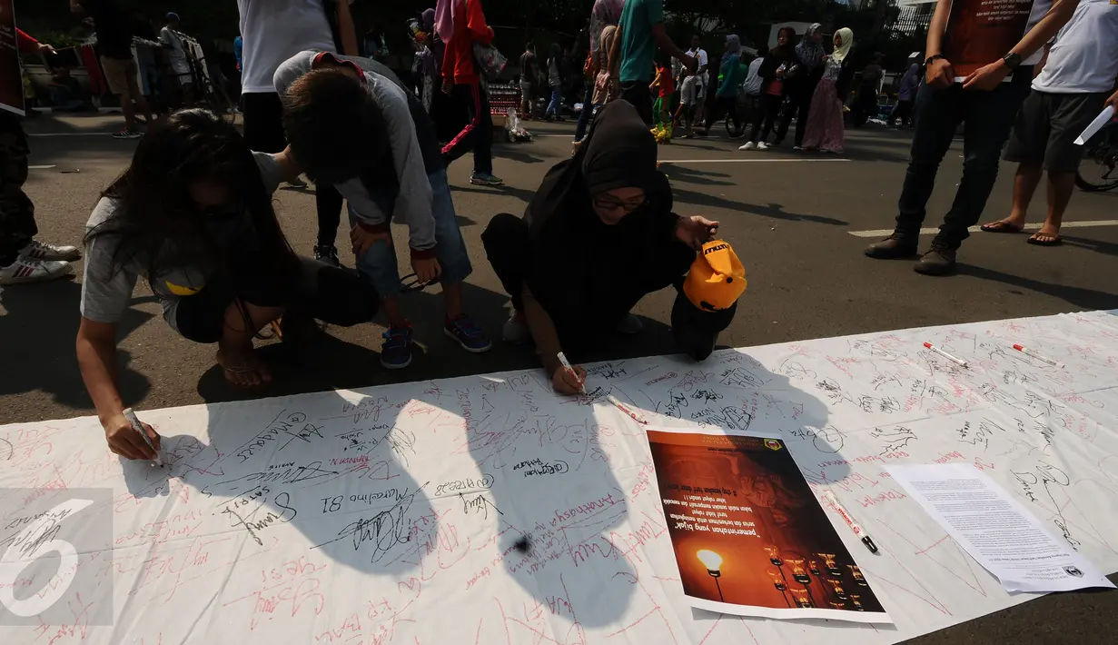 Warga menandatangani Petisi Penolakan Kenaikan Tarif Dasar Listrik di kawasan Bundaran HI, Jakarta, Minggu (7/5). Mereka menolak kebijakan kenaikan tarif dasar listrik yang diberlakukan per 1 Mei lalu. (Liputan6.com/Helmi Fithriansyah)
