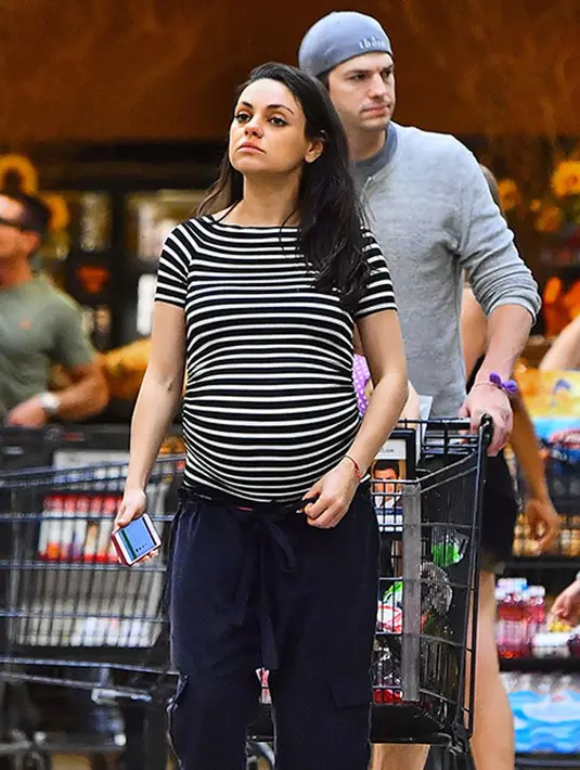 Ibu hamil ini mengenakan kaos garis-garis dan celana panjang berwarna Navy dengan rambut terurainya. Menemani sang istri, Ashton memakai kaos tangan panjang berwarna abu-abu, celana pendek hitam dan topi kupluknya.(doc.hollywoodlife)