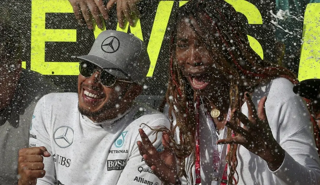 Pebalap Mercedes, Lewis Hamilton, merayakan kemenangan bersama petenis Venus Williams di Sirkuit Americas, Austin, Senin (24/10/2016) dini hari WIB. (Reuters/Adrees Latif)