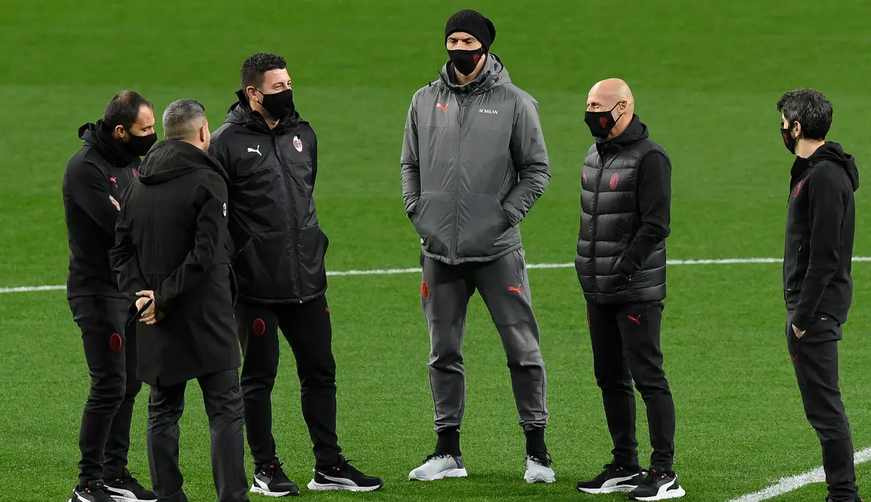 Penyerang AC Milan, Zlatan Ibrahimovic (tengah) berbincang  dengan pelatih Stefano Pioli (kedua kanan) saat berjalan di lapangan di Stadion Wanda Metropolitano di Madrid, Spanyol (23/11/2021). AC Milan akan bertanding melawan Atletico Madrid pada Grup B Liga Champions. (AFP/Oscar Del Pozo)