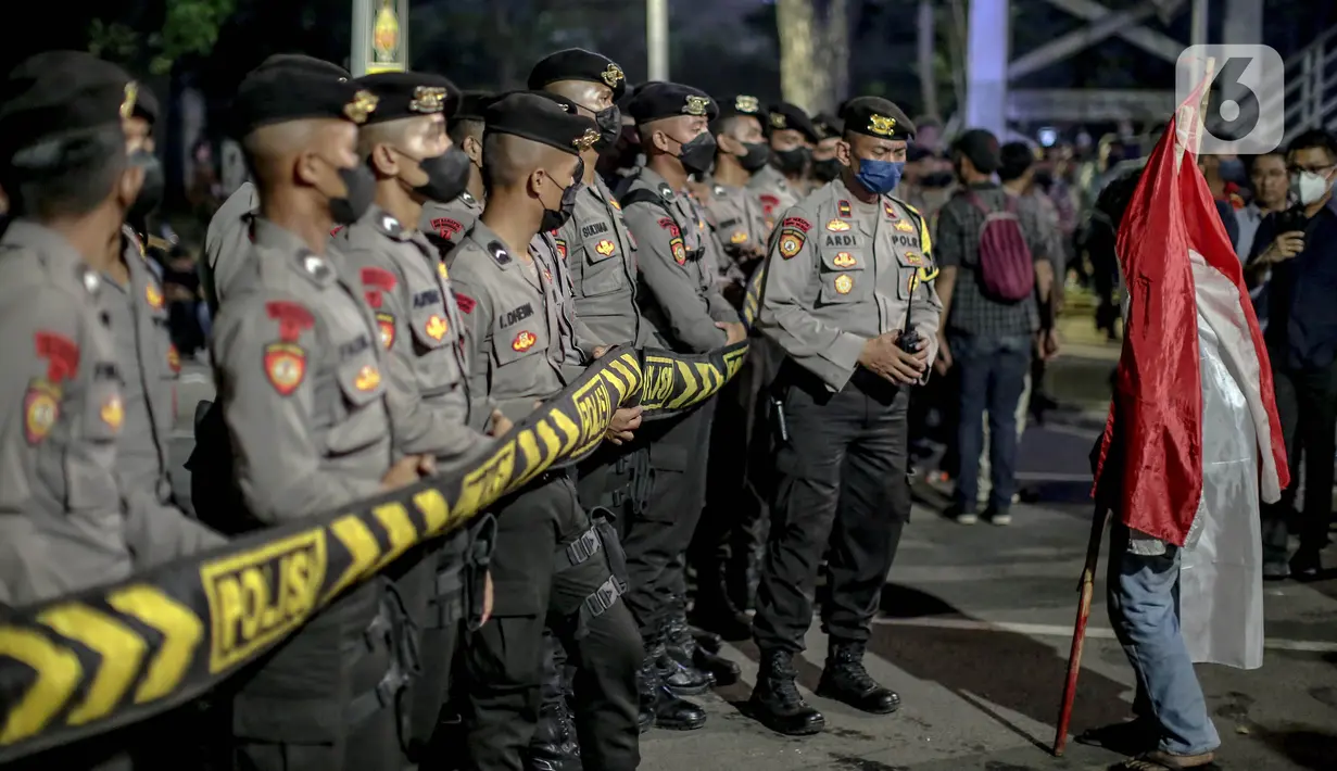 Petugas berjaga saat pengunjuk melakukan aksi menolak kenaikan harga BBM bersubdisi di kawasan Patung Kuda Arjuna Wijaya, Jakarta, Selasa (13/9/2022). Aksi unjuk rasa yang disertai membakar ban mobil bekas menolak kenaikan BBM subsidi. (Liputan6.com/Faizal Fanani)