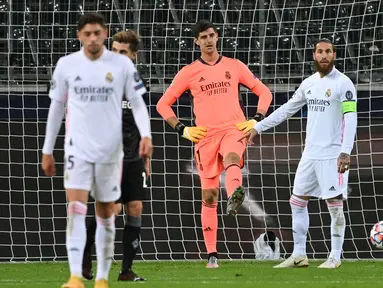 Kiper Real Madrid, Thibaut Courtois, tampak kecewa usai gawangnya kebobolan oleh Borussia Monchengladbach pada laga lanjutan Liga Champions di Borussia Park, Rabu (28/10/2020) dini hari WIB. Real Madrid bermain imbang 2-2 lawan Borussia Monchengladbach. (AFP/Ina Fassbender)
