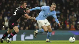 Pemain Manchester City, Erling Haaland (kanan) berebut bola dengan pemain Burnley, Jordan Beyer pada laga perempat final FA Cup 2022/2023 yang berlangsung di Etihad Stadium, Manchester, Minggu (19/03/2023) WIB. Haaland sukses mencetak hattrick untuk kemenangan 6-0 The Cityzens. (AP Photo/PA/Martin Rickett)