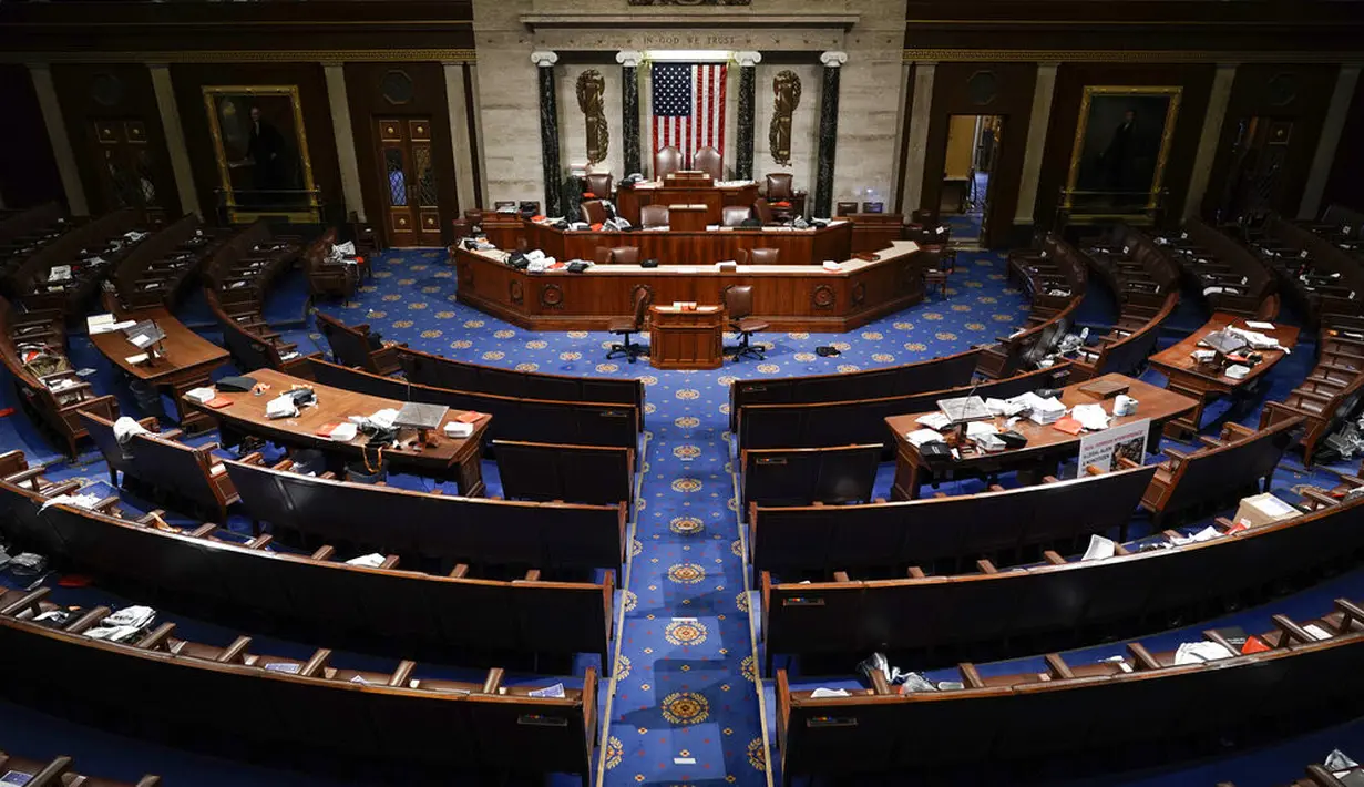 The House Chamber kosong setelah orang-orang dievakuasi saat pengunjuk rasa mencoba masuk ke Gedung Capitol Hill di Washington DC, Amerika Serikat, Rabu (6/1/2021). Ketua DPR Amerika Serikat Nancy Pelosi mengecam penyerbuan Gedung Capitol Hill. (AP Photo/J. Scott Applewhite)