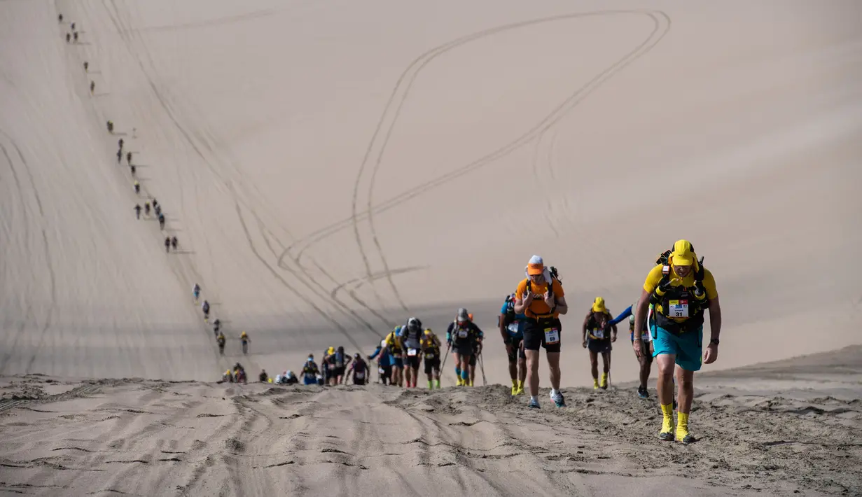 Peserta bersaing pada tahap kedua Half Marathon des Sables di Gurun Ica, Paracas, Peru, Selasa (3/12/2019). Para peserta harus menyelesaikan rute sejauh 109 Km. (Martin BUREAU/AFP)