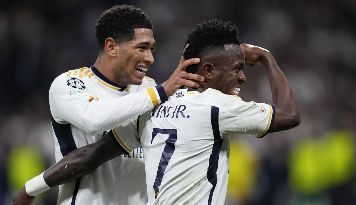 Pemain Real Madrid, Vinicius Jr (kanan) melakukan selebrasi bersama Jude Bellingham setelah mencetak gol ke gawang RB Leipzig pada laga leg kedua 16 besar Liga Champions 2023/2024 di Santiago Bernabeu, Madrid, Spanyol, Kamis (07/03/2024) WIB. (AP Photo/Manu Fernandez)
