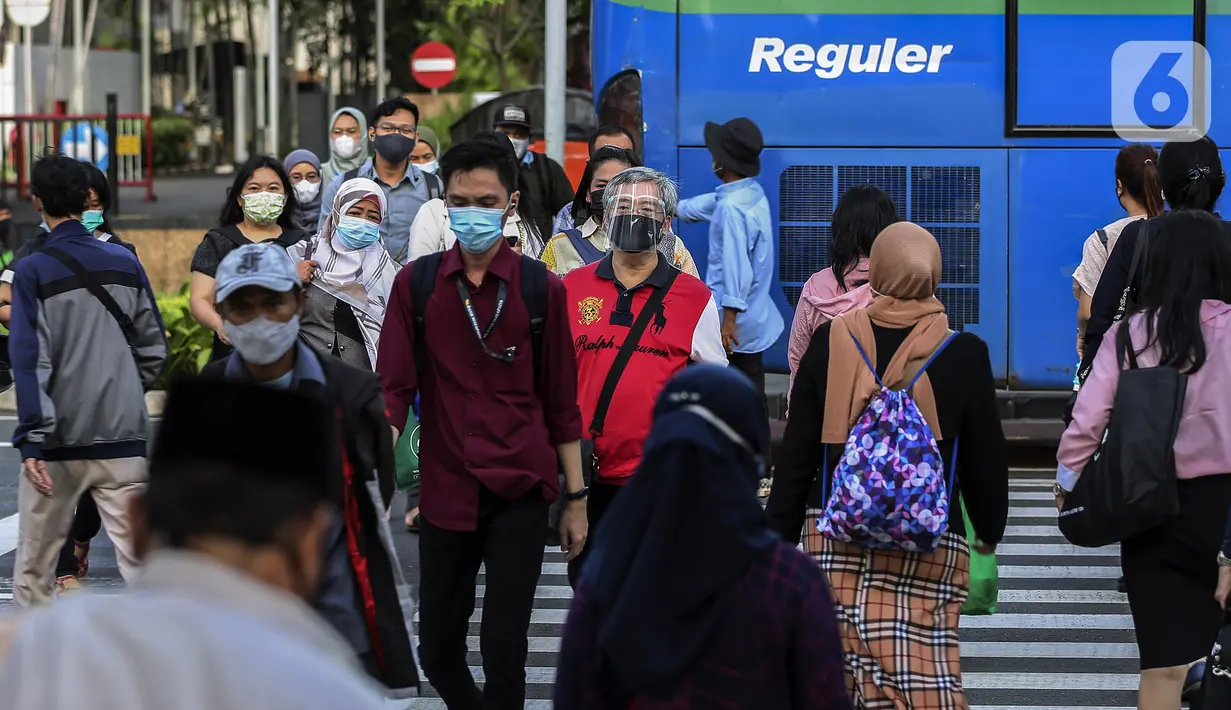Aktivitas pekerja pada saat jam pulang kantor di kawasan Sudirman, Jakarta, Selasa (18/5/2021). Jumlah perusahaan yang mendaftar program Vaksinasi Gotong Royong mencapai 22.736 perusahaan. (Liputan6.com/Johan Tallo)