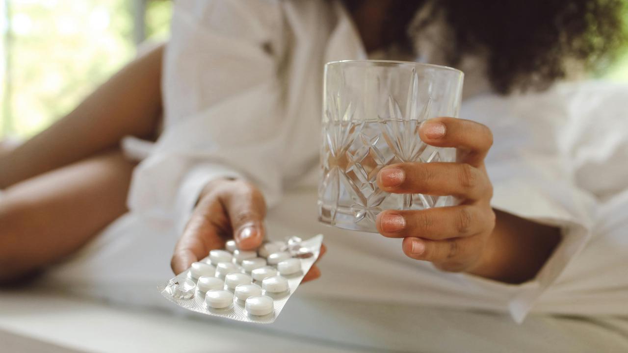 Wanita sedang minum obat