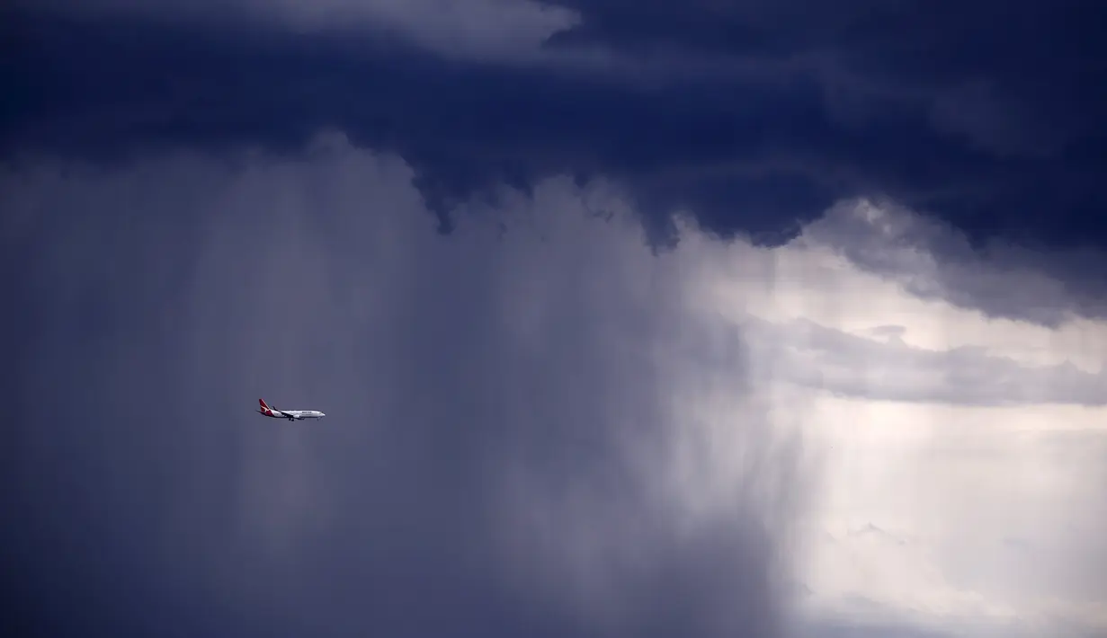 Sebuah pesawat melintasi awan gelap dengan  hujan lebat disertai badai menuju arah Sydney, Australia, Jumat (6/11/2015). Menurut Badan Meteorologi Australia akan ada badai besar diserta hujan lebat yang akan mengguncang Australia. (REUTERS/David Gray) 