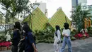 <p>Sejumlah warga berjalan melewati dekorasi bertemakan Idul Fitri di kawasan Bundaran HI, Jakarta, Rabu (27/4/2022). Dekorasi berbentuk masjid, ketupat, dan bedug yang dihiasi oleh tanaman tersebut dalam rangka menyambut Idul Fitri 1443 Hijriah. (Liputan6.com/Faizal Fanani)</p>
