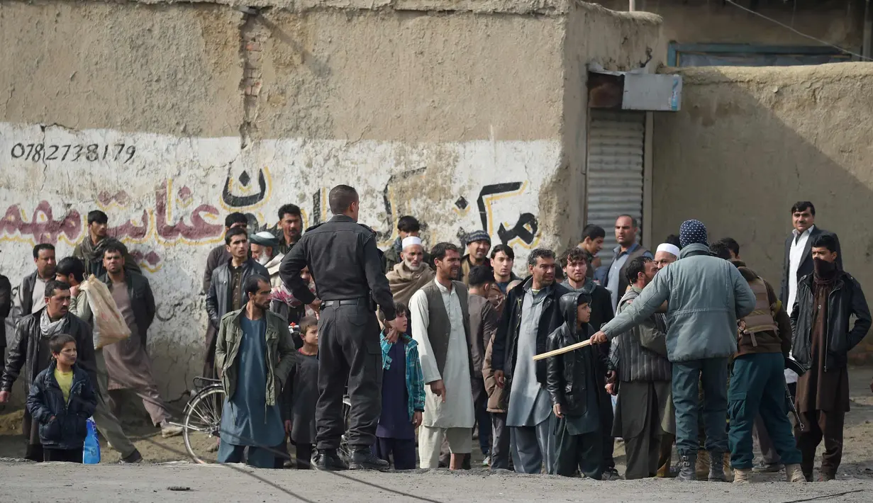 Sejumlah warga berkumpul di dekat lokasi serangan bom mobil bunuh diri yang menargetkan tentara asing di Kabul, (2/3). Ledakan menewaskan satu orang dan melukai empat lainnya. (AFP Photo/Wakil Kohsar)