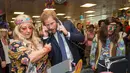 Pangeran Harry mengangkat dua telepon sekaligus saat menjadi broker dalam acara amal tahunan ICAP di London, Rabu (7/12). Pangeran Harry menjadi broker dadakan untuk mengumpulkan dana amal dari 60 kantor di seluruh dunia. (REUTERS/Geoff Pugh/Pool)