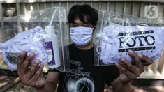 Anggota Pewarta Foto Indonesia Jakarta (PFIJ) menunjukkan paket penunjang liputan di Jakarta, Rabu (22/4/2020). PFIJ membagikan 230 paket penunjang liputan berupa masker, hand sanitizer, dan multivitamin kepada anggotanya yang melaksanakan tugas jurnalistik selama pandemi. (Liputan6.com/Johan Tallo)