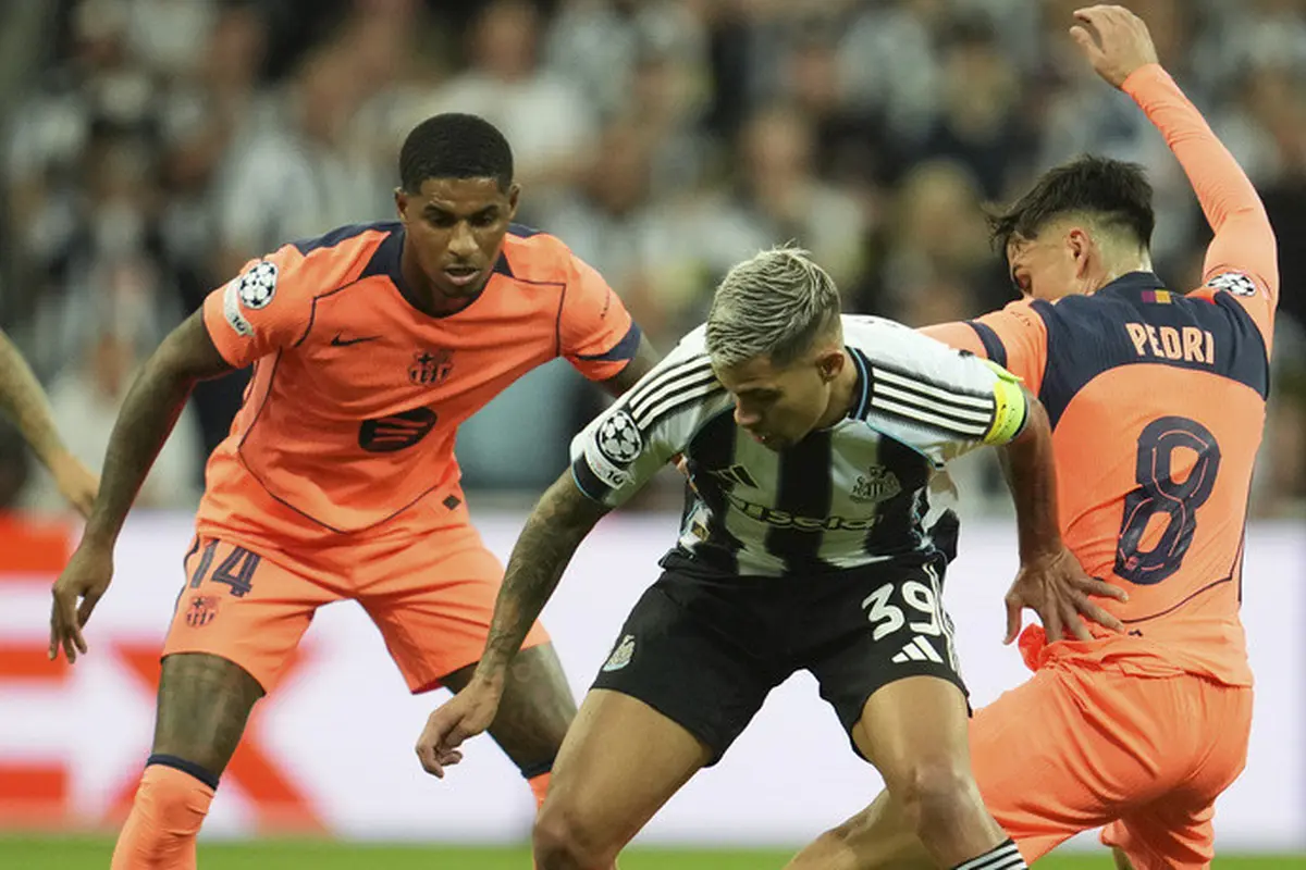 Pedri (kanan) berebut bola dengan Bruno Guimaraes di laga Newcastle vs Barcelona di Liga Champions 2025/2026 di St James' Park, Jumat (19/09/2025). (AP Photo/Jon Super)