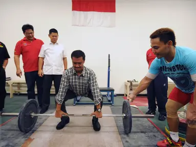 Menpora Imam Nahrawi (keempat kiri) bersiap melakukan angkatan saat meninjau kesiapan akhir atlet angkat besi di PB PABBSI, Jakarta, Selasa (21/6). Tujuh atlet angkat besi akan berlaga di Olimpiade Rio 2016. (Liputan6.com/Helmi Fithriansyah)