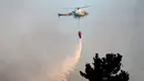 Sebuah helikopter membawa air untuk memadamkan api yang melanda kawasan Dichato Chili, Senin (30/1). Diperkirakan api telah melalap sekitar 680.000 are lahan. (AP Photo / Esteban Felix)