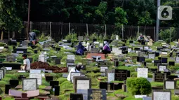 Warga berziarah di makam keluarganya di Tempat Pemakaman Umum (TPU) Tanah Kusir, Jakarta, Selasa (29/3/2022). TPU setempat semakin banyak dikunjungi warga yang melakukan tradisi ziarah kubur menjelang Ramadhan. (Liputan6.com/Johan Tallo)